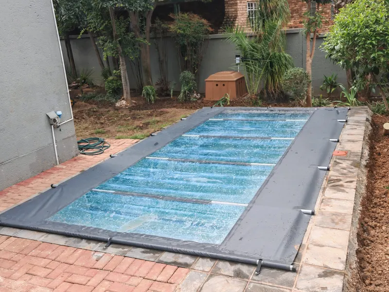 A grey cover with clear panels over a pool