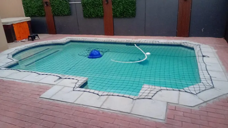A safety net over a pool with a stepped edge