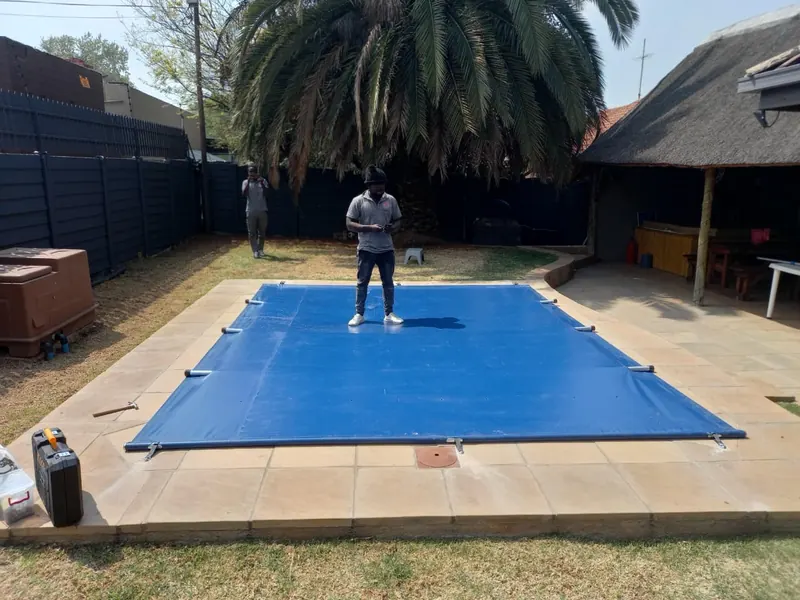 A man standing on a fitted blue PVC cover